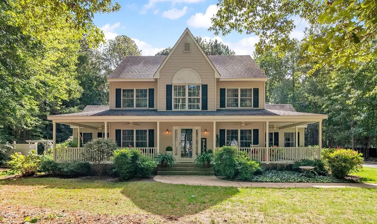 Two-story home with a shingle roof and wraparound porch