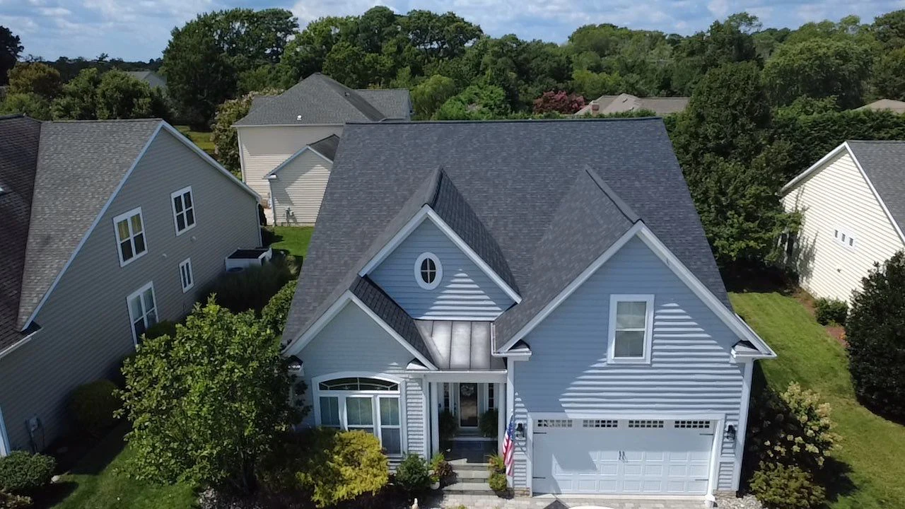 Aerial view of a completed charcoal shingle roof with multiple gables